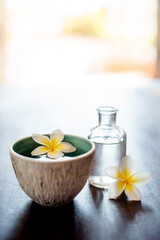 Flower, spa and essential oil on table with peace, natural product and bowl for fragrance. Holistic health, hospitality service and counter with aromatherapy for self care at luxury wellness salon