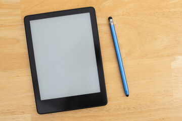 Ereader with a stylus on a wooden desk