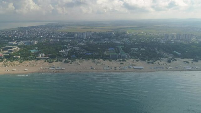 City with a beach and a body of water in the background. The sky is cloudy and the beach is empty. The Black Sea coast in Anapa at the height of the summer season.