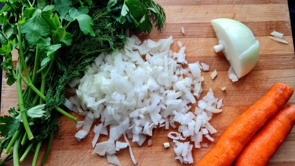 Onions, carrots and greens on a cutting board
