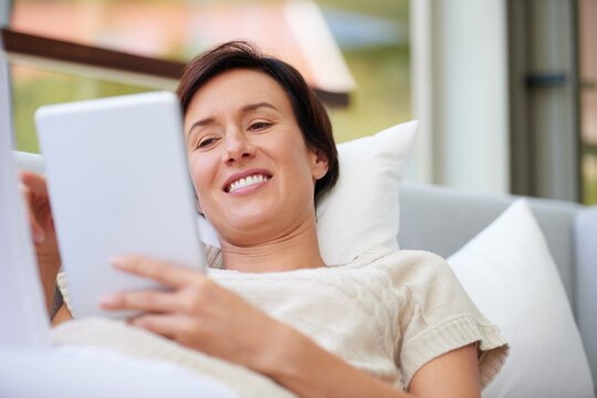 Sofa, relax and woman with tablet for ebook, online entertainment and web subscription at home. House, female person and happy with digital for interactive app, social media and game in living room