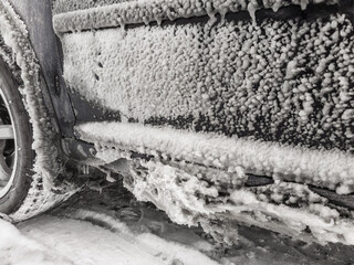 Fototapeta premium ice layer formed on car door at winter freezing rain on the road