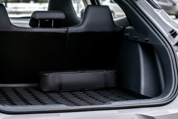 The big black empty trunk of SUV car with rubber mat and a tool box. Open luggage carrier of car closeup © Air_Lady