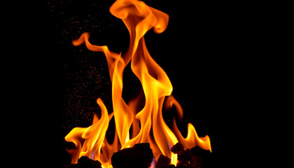 Fototapeta premium Close-up of intense flames with twisting orange and yellow patterns rising into the dark air, symbolizing heat, power, and destruction, creating a visually striking and dramatic fire effect.