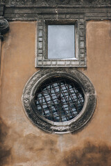 Large antique round and rectangular window with bars on the Boim Chapel in Lviv, Ukraine. Decorative element of an old Renaissance building.
