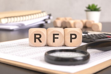 RFP- Request For Proposal word written on a wooden block with magnifier and calculator, business concept.