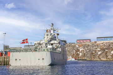 Danish nautical military force guard military ship with Danish flag on the stern waving on the wind, docked at pier in Nuuk city, Greenland © vadim.nefedov