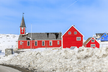 Red buildings with clock tower among the snow, Annaassisitta Oqaluffia, church of our Saviour Historical center of Nuuk, Greenland © vadim.nefedov