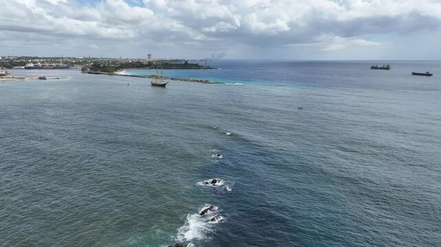 Santo Domingo, Dominican Republic, aerial video footage of three masted square rigger "Alexander von Humboldt 2", a German sailing ship, leaving the port, city Santo Domingo in background  