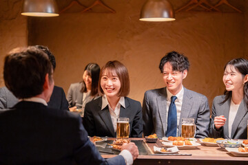 居酒屋で新入社員の歓迎会をするビジネスパーソン