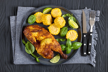half of bbq chicken with corn cobs coins and basil