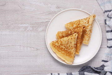 Breakfast with pancakes, cream, and coffee on a wooden table during the morning