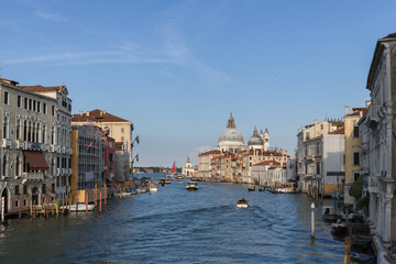 Grand Canal top attraction in Venice, Italy with beautiful architectural buildings, busy water traffic, and a majestic church Santa Maria della Salute.