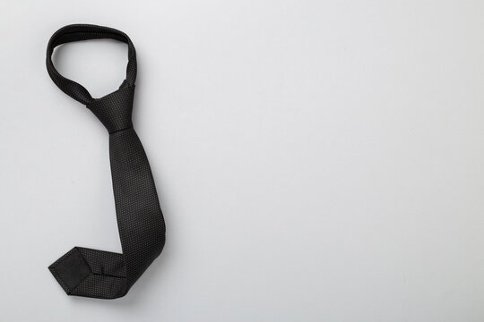 Black tie on color background, top view