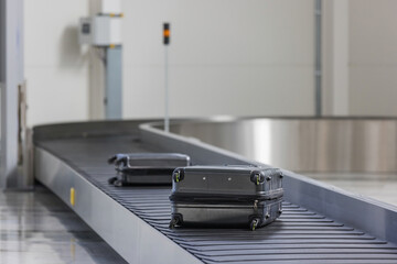 Baggage claim at an airport, two suitcases on a conveyor belt at an arrival area. Travel,...