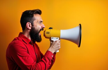 Man wearing red shirt shouting into yellow, white megaphone against orange background. Beard, looks loud. Communicating important message, making announcement, giving speech. Image shows concept of