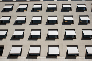 Boring gray facade of office building in Stockholm, Sweden. Abstract photo of windows on a completely monotone grey wall. 