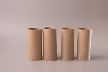 four empty toilet paper rolls against grey background