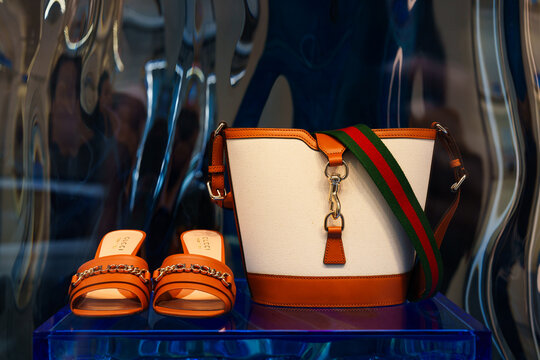 Milan, Italy - 24.04.2024: Elegant Gucci handbag and sandals display with fashionable accessories.