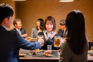 居酒屋で新入社員の歓迎会をするビジネスパーソン