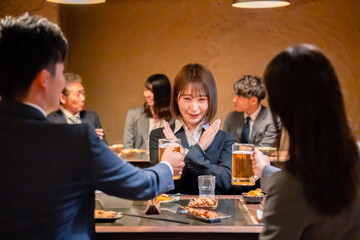 居酒屋で新入社員の歓迎会をするビジネスパーソン