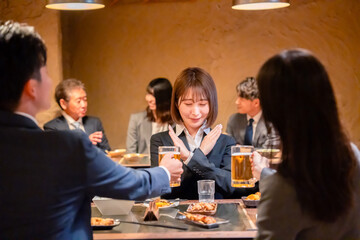 居酒屋で新入社員の歓迎会をするビジネスパーソン
