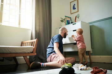Getting ready, children and a man helping his son to pick an outfit from the cupboard in a bedroom....