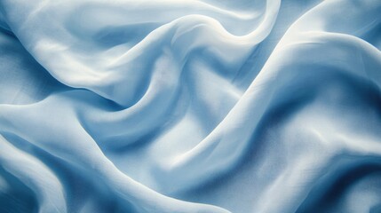Obraz premium Close-up of soft cotton fabric with delicate folds, pastel blue background.