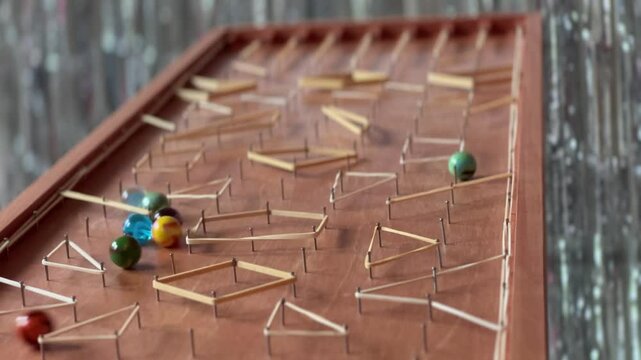 Handmade marble racing game with rubber band obstacles