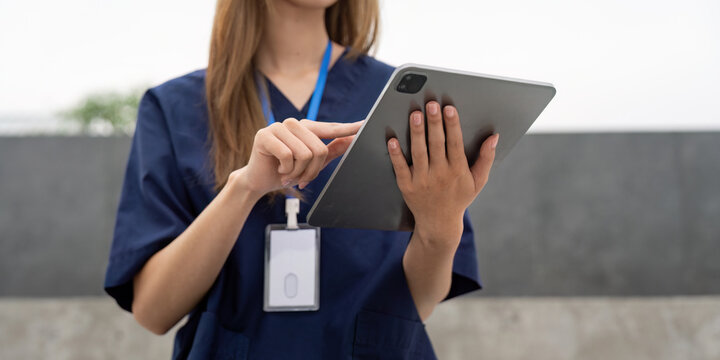 Nurse using a tablet for patient care and documentation during a break
