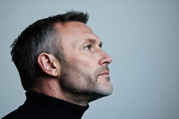 Obraz premium A man with a beard and gray hair is looking up at the camera