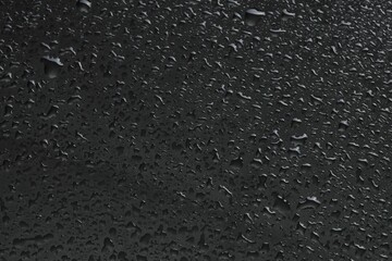 Water drops on grey glass surface, top view
