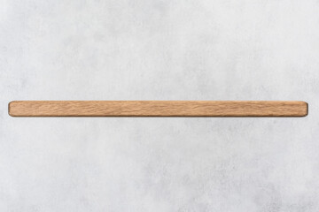 A long wooden board is sitting on a white wall