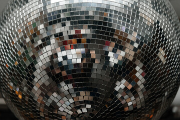 disco ball with mirror surface and bright rays, hanging on ceiling, night party background