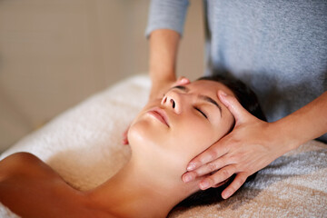 Face, massage and girl on table at spa for skincare, peace and acupressure with luxury hotel service. Relax, self care and woman on bed at beauty salon for holistic facial, wellness or skin treatment