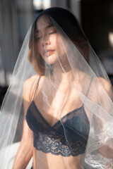 Asian model portrait in bedroom studio.