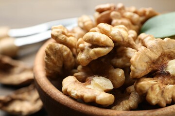 Peeled walnuts in bowl on table, closeup