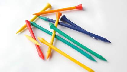 A set of golf tees in different colors, arranged neatly on a white background, showing their slender design and sharp tips