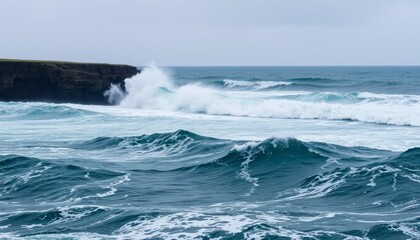 Fototapeta premium Powerful Ocean Waves Crashing Against Dark Rocks on a Cloudy Day