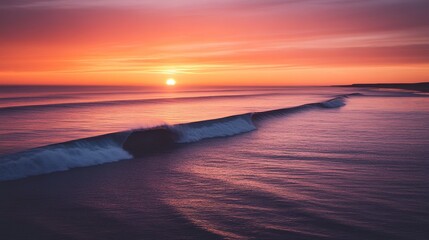 Fototapeta premium A serene sunset over calm ocean waves, casting vibrant hues of orange, pink, and purple across the sky and water.