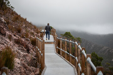 man behind walking path hike mountains cold winter jacket