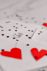 A handwritten note expresses love with the words I love you alongside a silver ring placed on a red paper heart, creating a romantic setting. Happy Valentine's Day