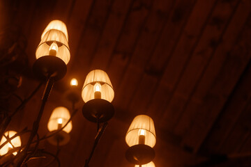 A group of lamps with a warm glow. The lamps are lit up and are placed in a room