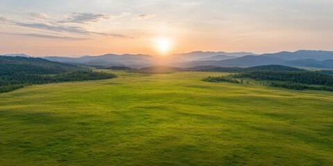 Obraz premium Serene Sunset Over Lush Green Meadow and Mountains