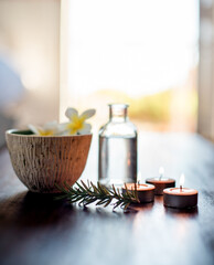 Flowers, rosemary in water and candles in spa for wellness or beauty treatment. Salon aesthetic, holistic service and jar with herbs for cosmetics, aromatherapy and health for zen, calm or peace