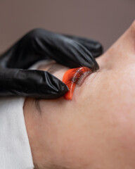 Caucasian woman undergoing eyelash lamination procedure. 