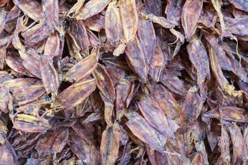 closeup dried squid pile or fresh or raw and many rare dry seafood for iodine food in street fishing market at thailand