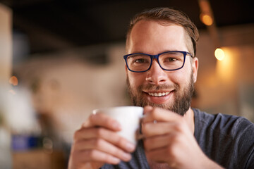 Coffee, happy and portrait of man with glasses in cafe for digital nomad career with travel for creativity. Remote work, cappuccino and copywriter with drink in restaurant on morning for project.