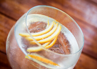 High-angle close-up of a chilled gin and tonic in an elegant glass, with glistening ice cubes and a...