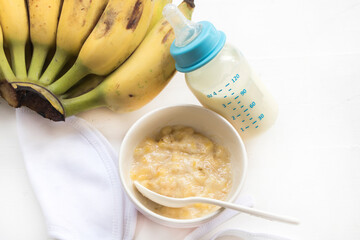 mashed banana healthy foods, milks in bottle of baby eats arrangement flat lay style on background white